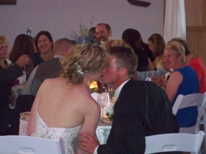 Becky and Travis kiss at sweetheart table
